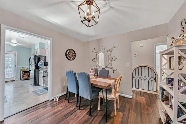 a dining room with furniture a chandelier and wooden floor