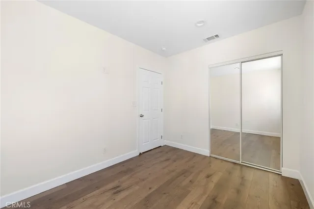 an empty room with wooden floor and closet