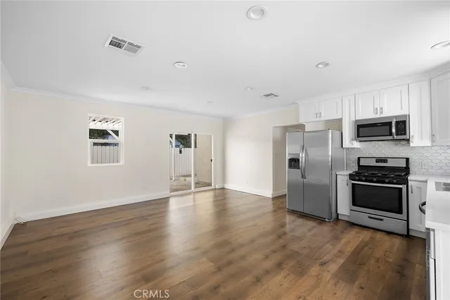 a view of a kitchen with refrigerator stove and wooden floor