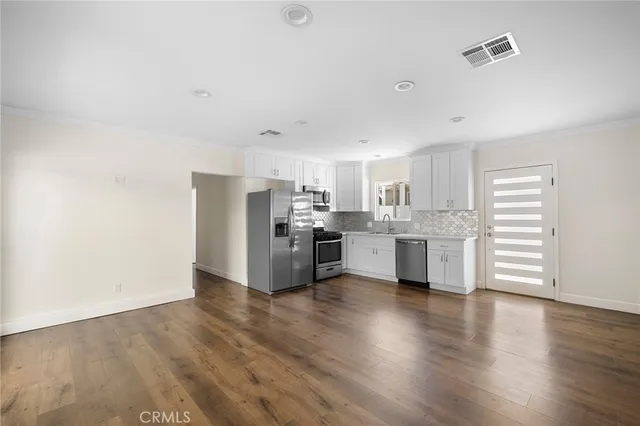 a kitchen with stainless steel appliances a refrigerator sink and cabinets