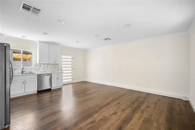 a view of a kitchen with a sink a stove and cabinets