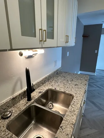 a bathroom with a granite countertop sink a mirror and vanity
