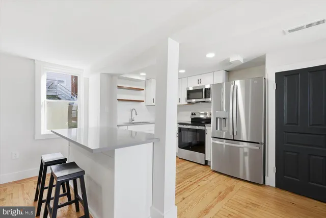 a kitchen with a refrigerator and a stove top oven