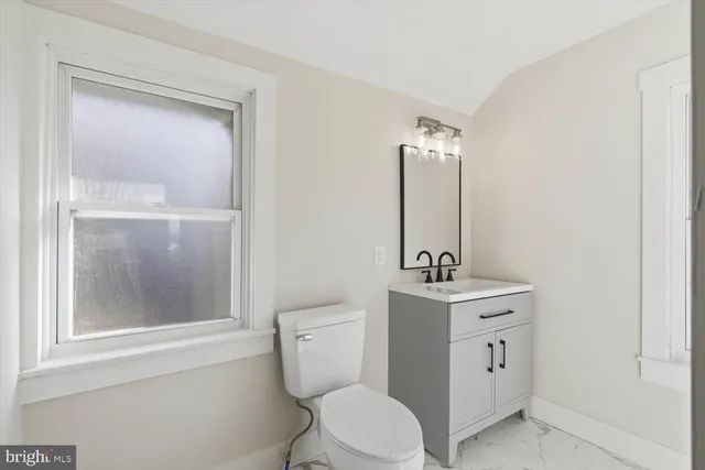 a bathroom with a toilet a sink and mirror