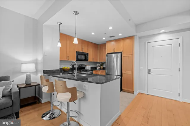 a living room with furniture a flat screen tv and kitchen view