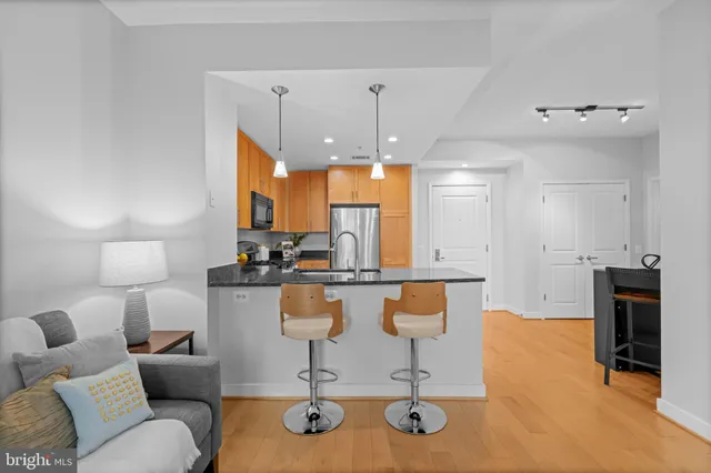 a kitchen with stainless steel appliances granite countertop a stove top oven a sink a dining table and chairs