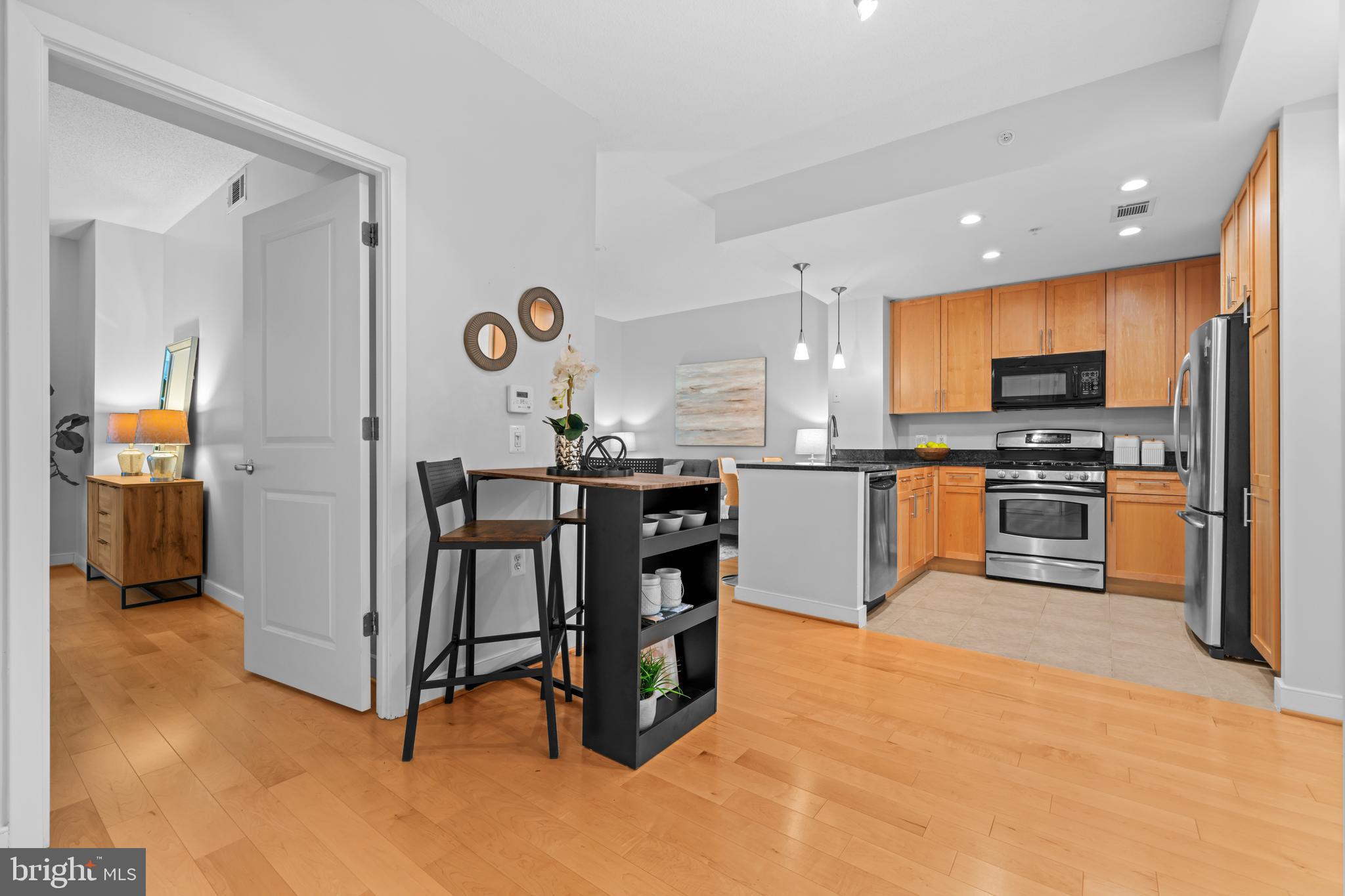 820 North Pollard Street, Unit 307 Arlington, VA 22203 - Photo 14 of 29 a kitchen with stainless steel appliances granite countertop a stove top oven a sink a dining table and chairs