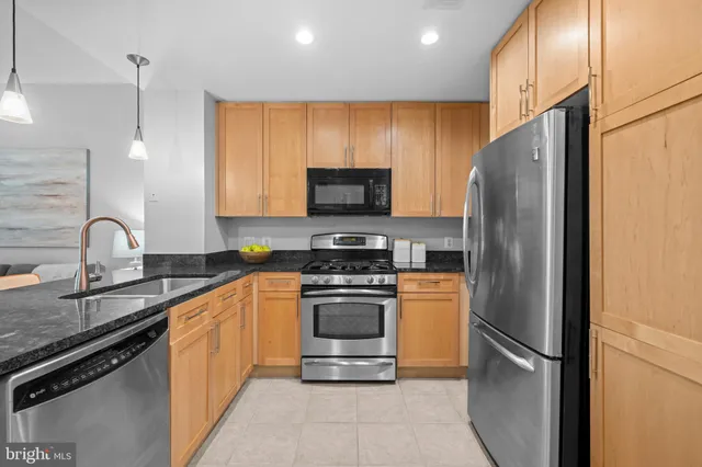 a kitchen with stainless steel appliances granite countertop a refrigerator stove and sink