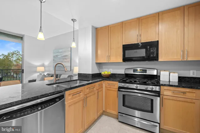 a kitchen with stainless steel appliances granite countertop a sink stove and microwave
