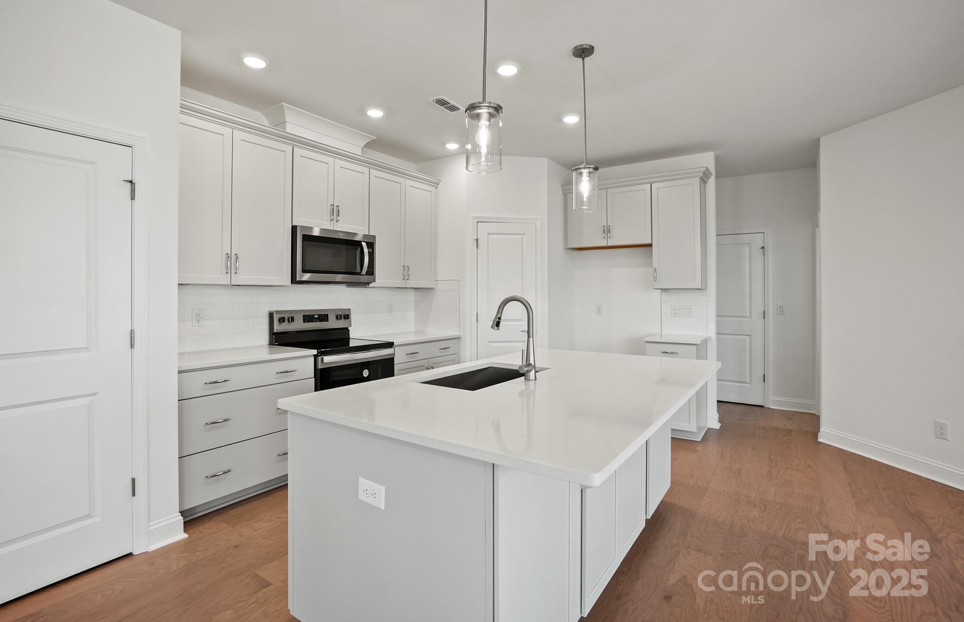 2234 Millenium Drive, Unit 84 Lancaster, SC 29720 - Photo 13 of 37 a kitchen with white cabinets and stainless steel appliances