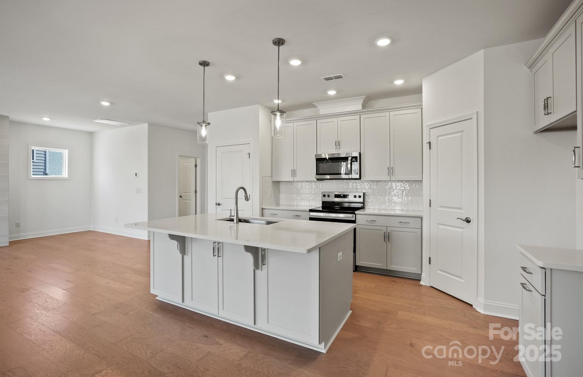 2234 Millenium Drive, Unit 84 Lancaster, SC 29720 - Photo 15 of 37 a kitchen with stainless steel appliances kitchen island a sink a stove a refrigerator and white cabinets