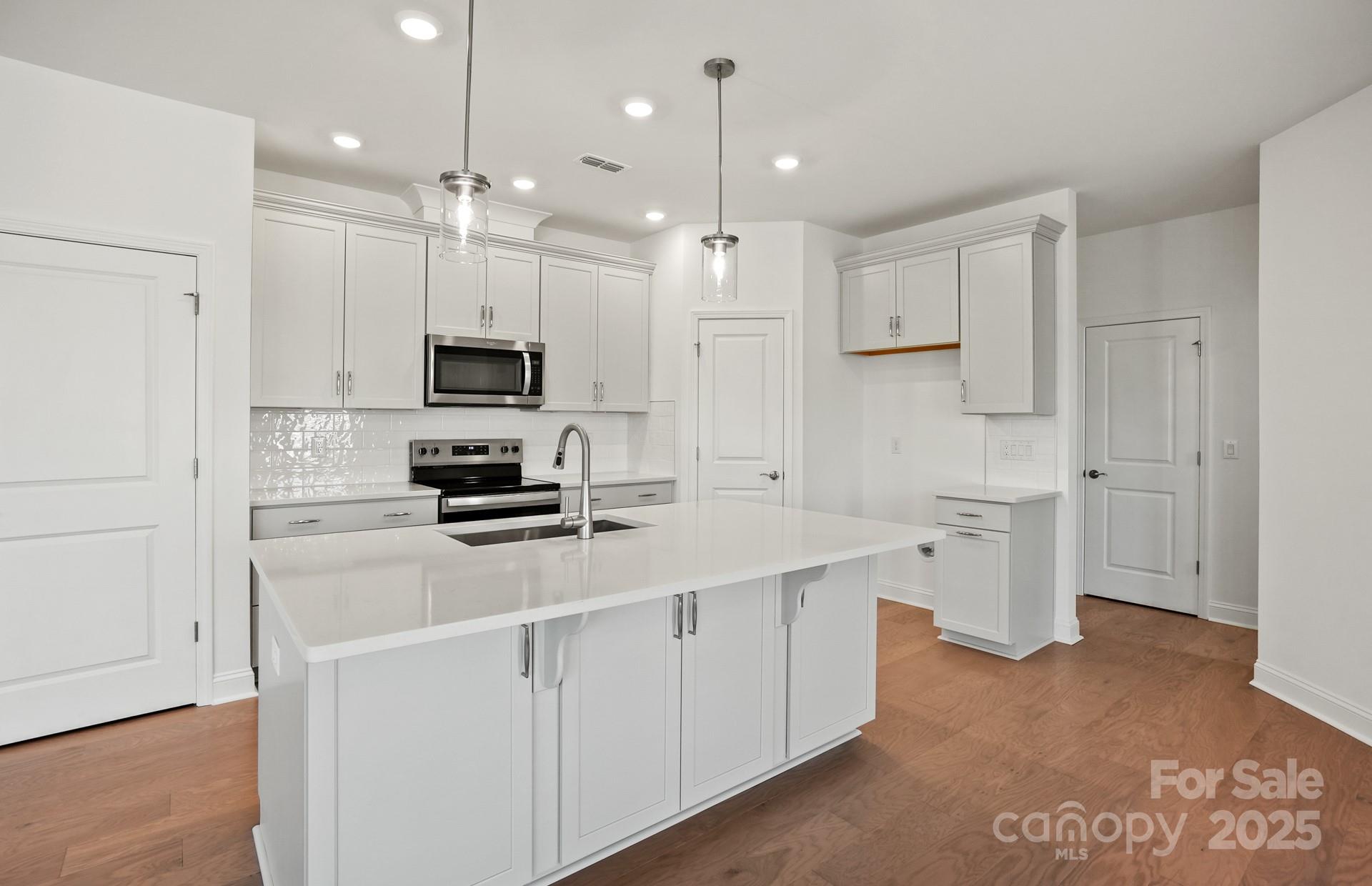 2234 Millenium Drive, Unit 84 Lancaster, SC 29720 - Photo 17 of 37 a kitchen with white cabinets and stainless steel appliances