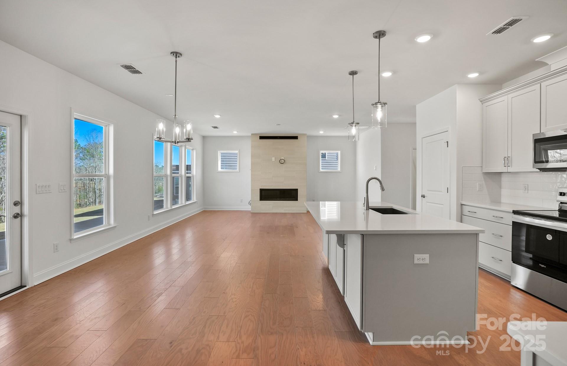 2234 Millenium Drive, Unit 84 Lancaster, SC 29720 - Photo 19 of 37 a large kitchen with stainless steel appliances kitchen island granite countertop a stove a refrigerator a oven and a wooden floors