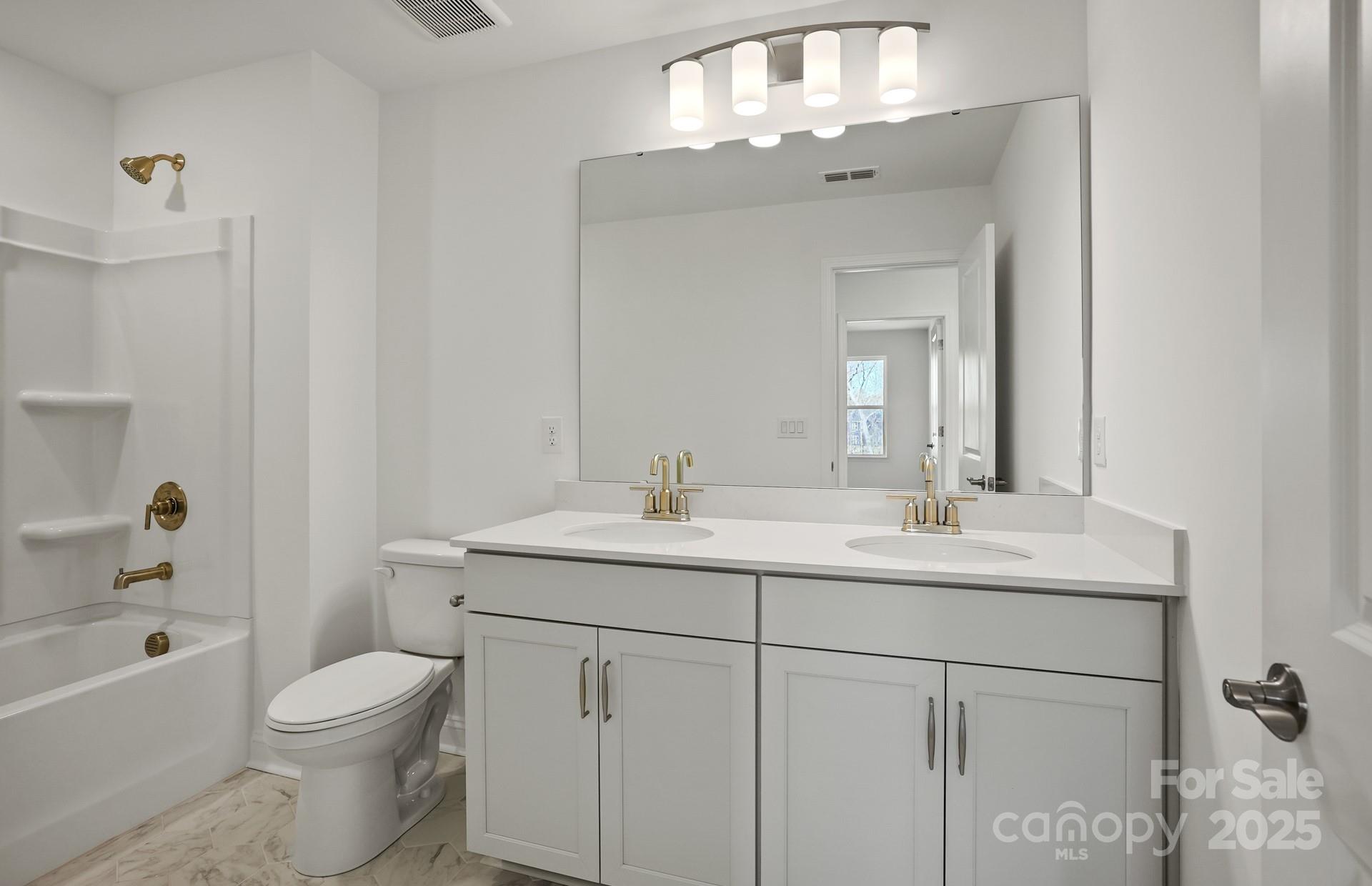 2234 Millenium Drive, Unit 84 Lancaster, SC 29720 - Photo 25 of 37 a bathroom with a toilet a sink a tub and mirror