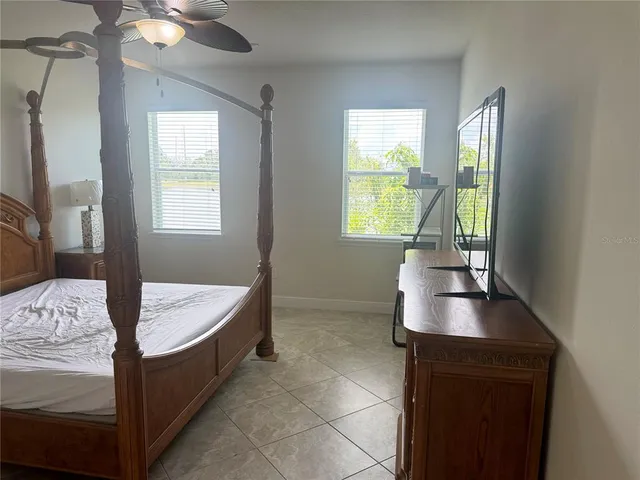 a living room with a bed furniture and a flat screen tv