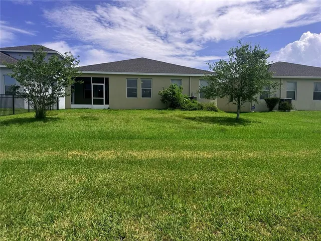 a front view of a house with a yard and trees