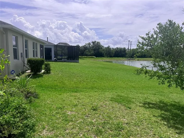 a front view of a house with garden and a tree