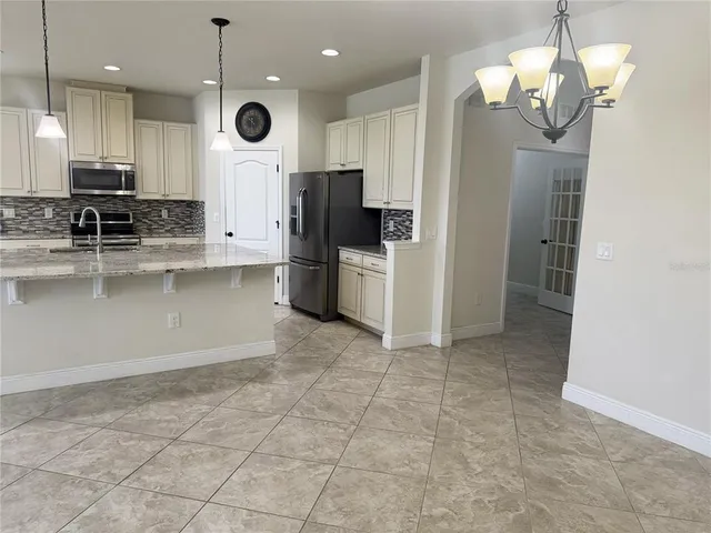 a large kitchen with a large counter top space appliances and cabinets