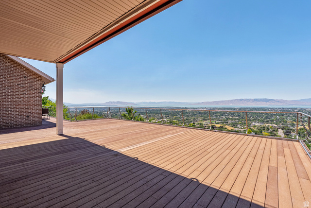 4093 North Imperial Way Provo, UT 84604 - Photo 36 of 96 Expansive outdoor deck featuring wood-finish flooring, a contemporary cable railing system, and a scenic backdrop of distant mountains and a body of water
