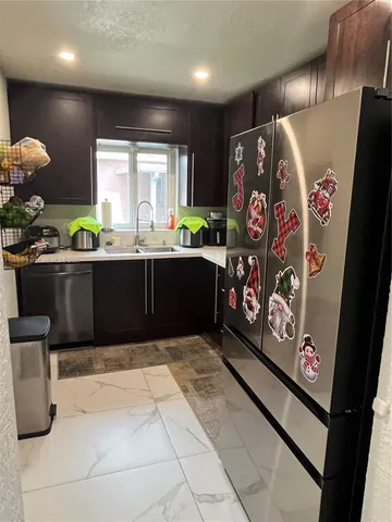 a view of kitchen with stainless steel appliances kitchen island granite countertop a refrigerator and a stove