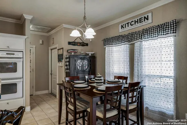a view of a dining room with furniture a chandelier and window