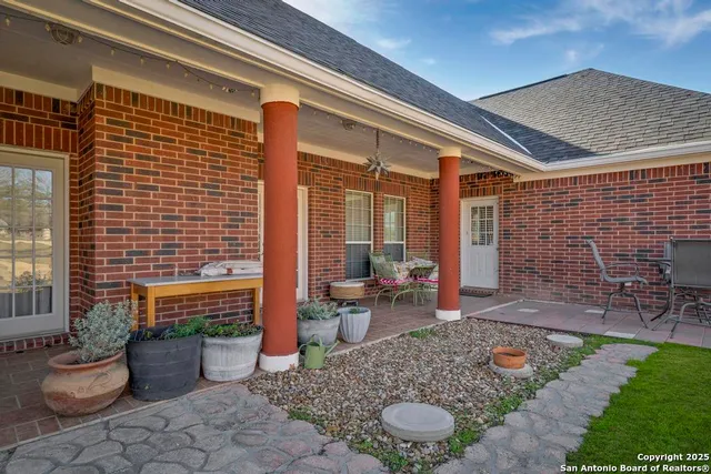 a view of a patio with couple of chairs and a potted plant