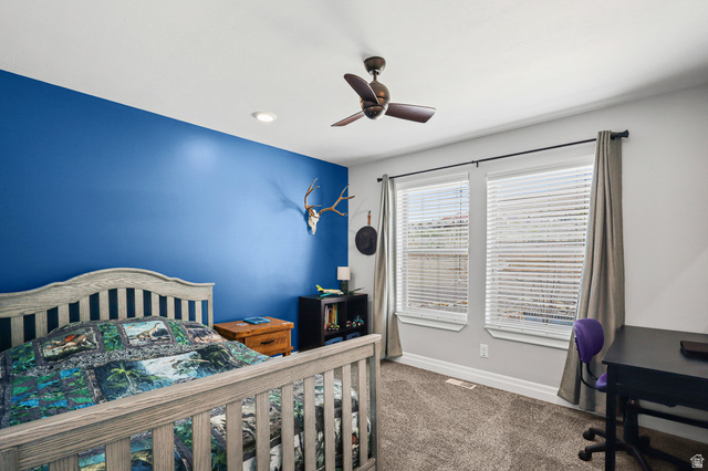 1588 West Rim Rock Drive Stockton, UT 84071 - Photo 24 of 61 Bedroom featuring a deep blue accent wall, neutral carpeting, and a ceiling fan with integrated lighting