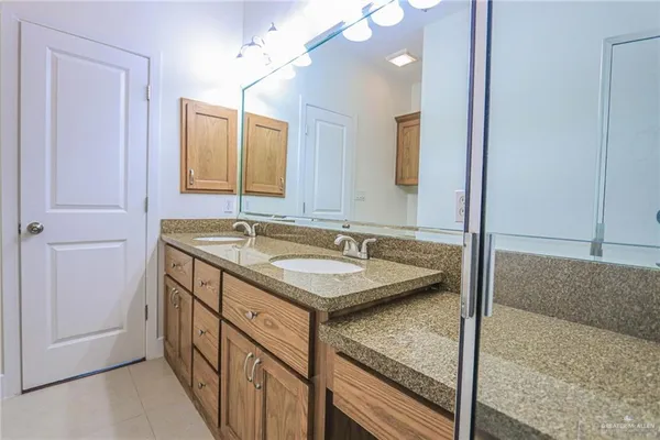 a bathroom with a granite countertop sink and a mirror