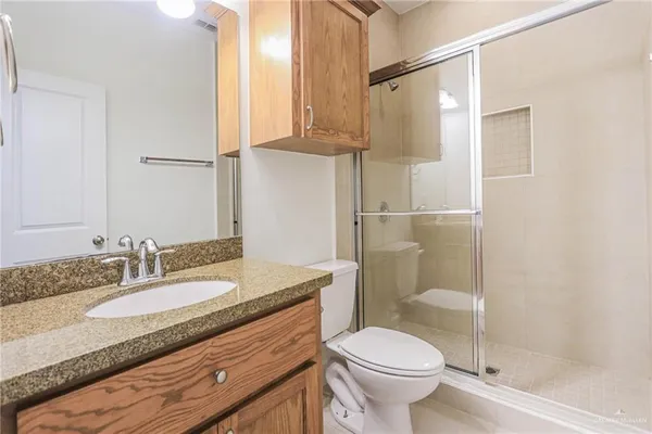 a bathroom with a granite countertop sink toilet and shower