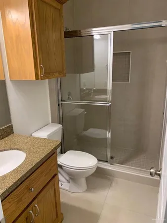 a bathroom with a granite countertop sink toilet and shower
