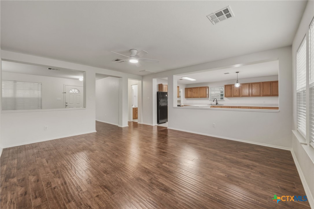 109 Comal Cove Elgin, TX 78621 - Photo 5 of 34 a view of a livingroom with wooden floor and a kitchen