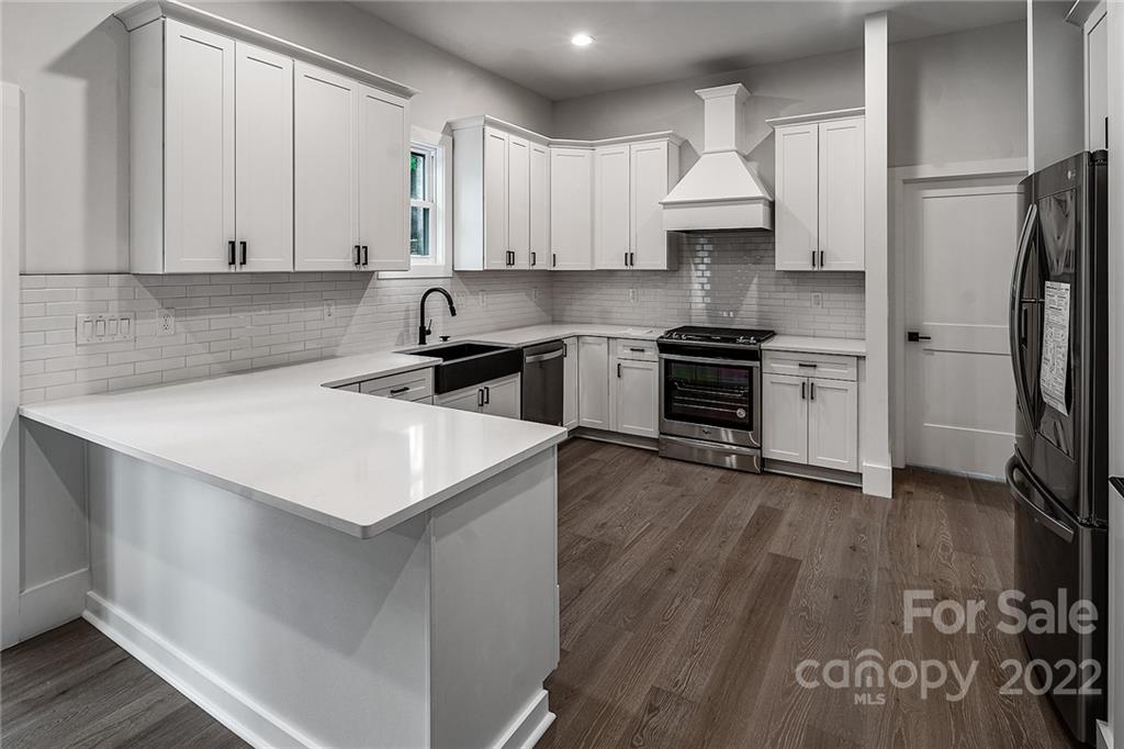 16025 Kiki Court Tega Cay, SC 29708 - Photo 14 of 39 a kitchen with stainless steel appliances white cabinets and a stove