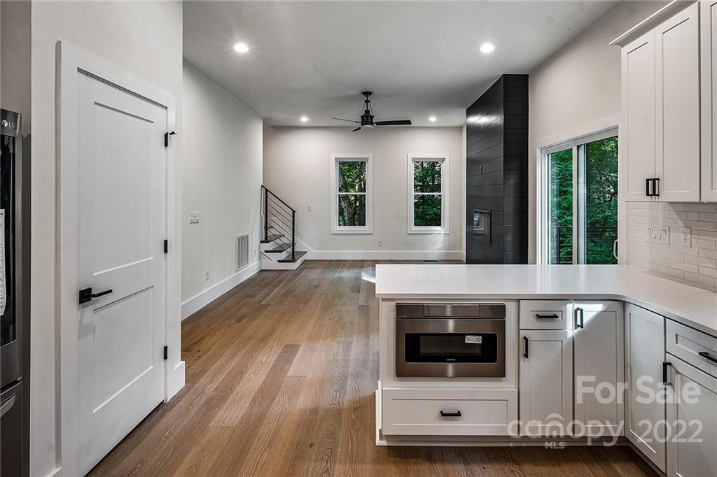 16025 Kiki Court Tega Cay, SC 29708 - Photo 15 of 39 a living room with stainless steel appliances wooden floor and white cabinets