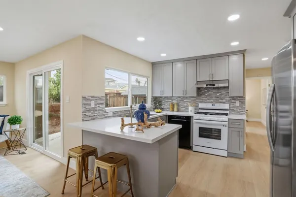 a kitchen with stainless steel appliances granite countertop a sink stove and refrigerator