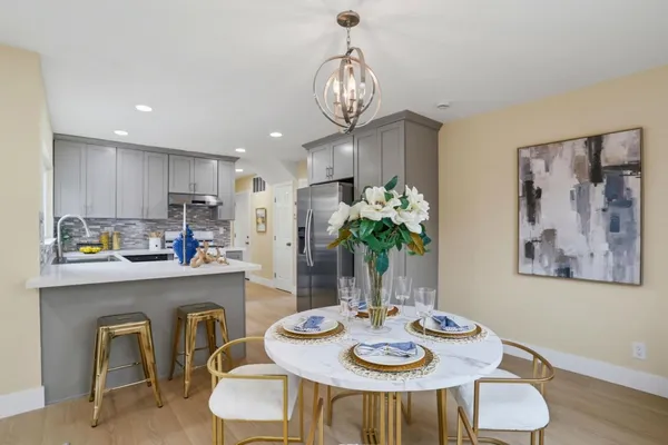 a view of a dining room and kitchen with furniture wooden floor and a chandelier