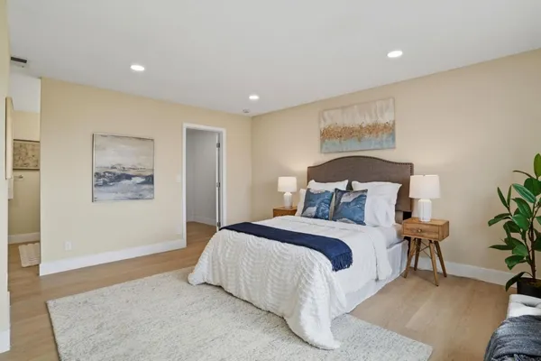 a bedroom with a bed and a painting on the wall