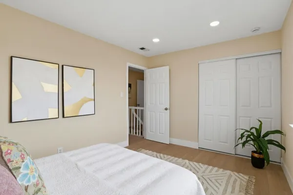 a bedroom with a bed and a painting on the wall