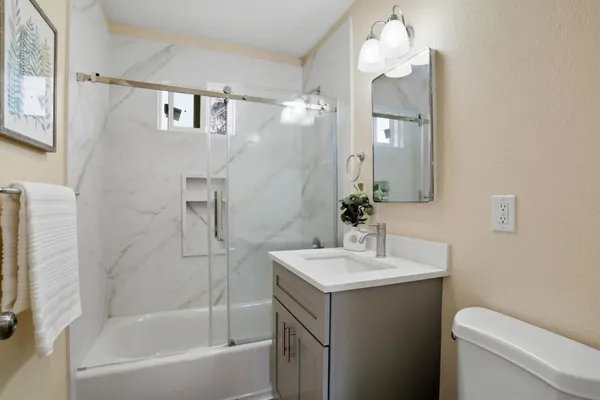 a bathroom with a sink a toilet and shower