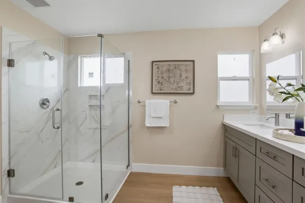 a bathroom with a shower sink and mirror