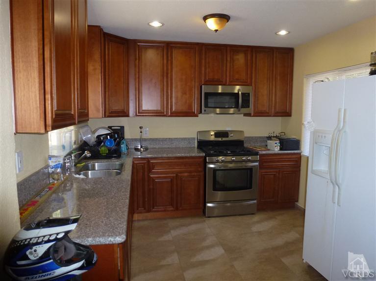 4591 Apricot Road Simi Valley, CA 93063 - Photo 6 of 15 a kitchen with a refrigerator and a stove top oven