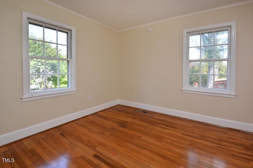 1817 Hillcrest Drive Durham, NC 27705 - Photo 14 of 29 an empty room with wooden floor and windows