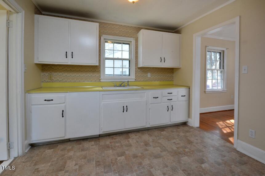 1817 Hillcrest Drive Durham, NC 27705 - Photo 16 of 29 a kitchen with granite countertop white cabinets and a window