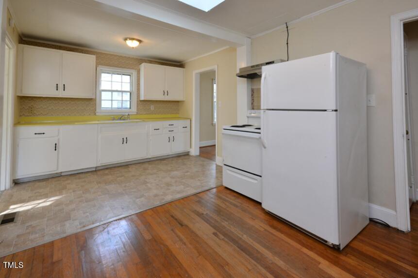 1817 Hillcrest Drive Durham, NC 27705 - Photo 21 of 29 a kitchen with white cabinets and white appliances