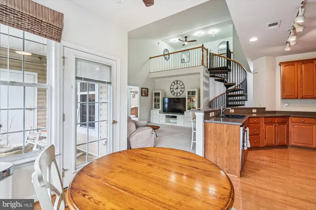 a balcony with table and chairs and wooden floor