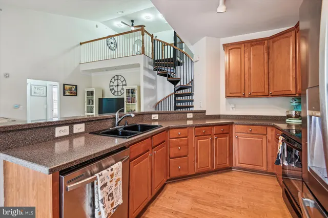 a kitchen with a sink and a stove top oven with wooden floor