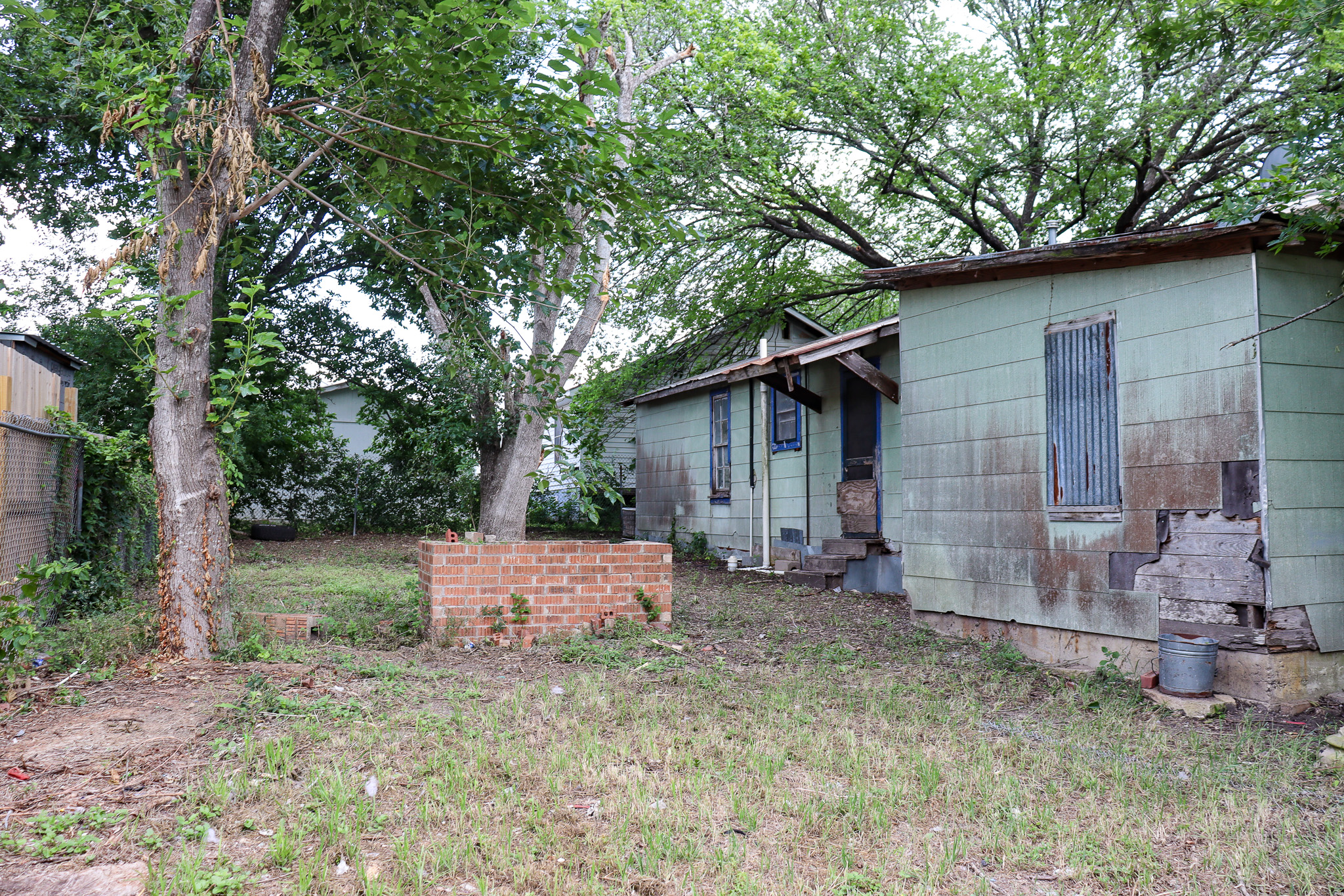 803 3rd Street Lockhart, TX 78644 - Photo 8 of 15 a backyard of a house with a large tree and wooden fence