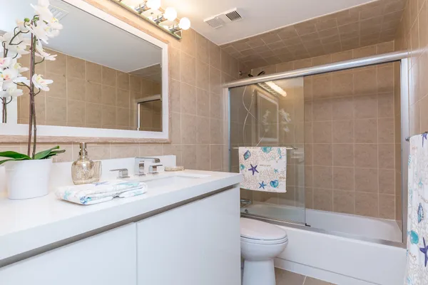 a bathroom with a sink a toilet and shower