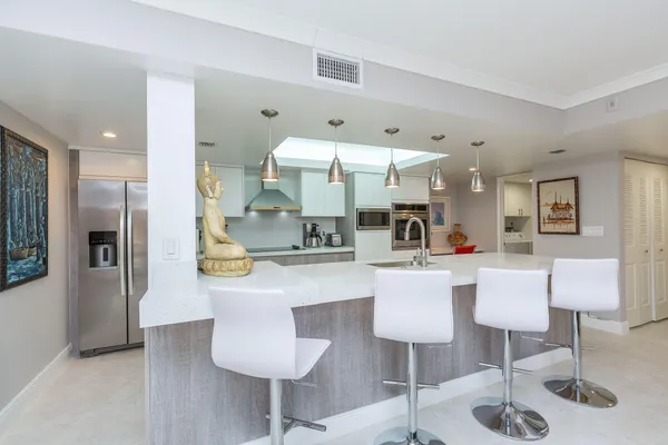 a view of living room with stainless steel appliances kitchen island granite countertop furniture and a view of kitchen