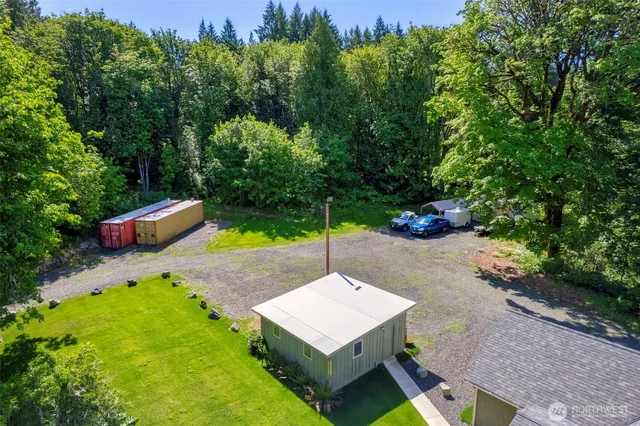 a view of a house with a big yard and large trees