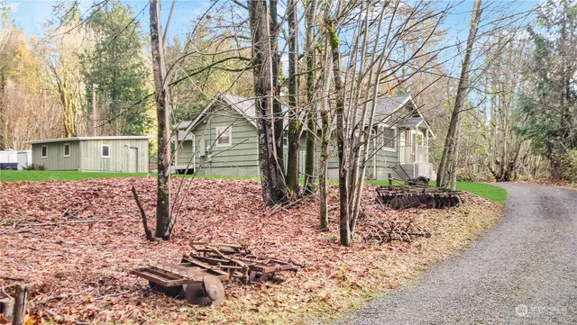 a view of a house with a yard and covered with trees